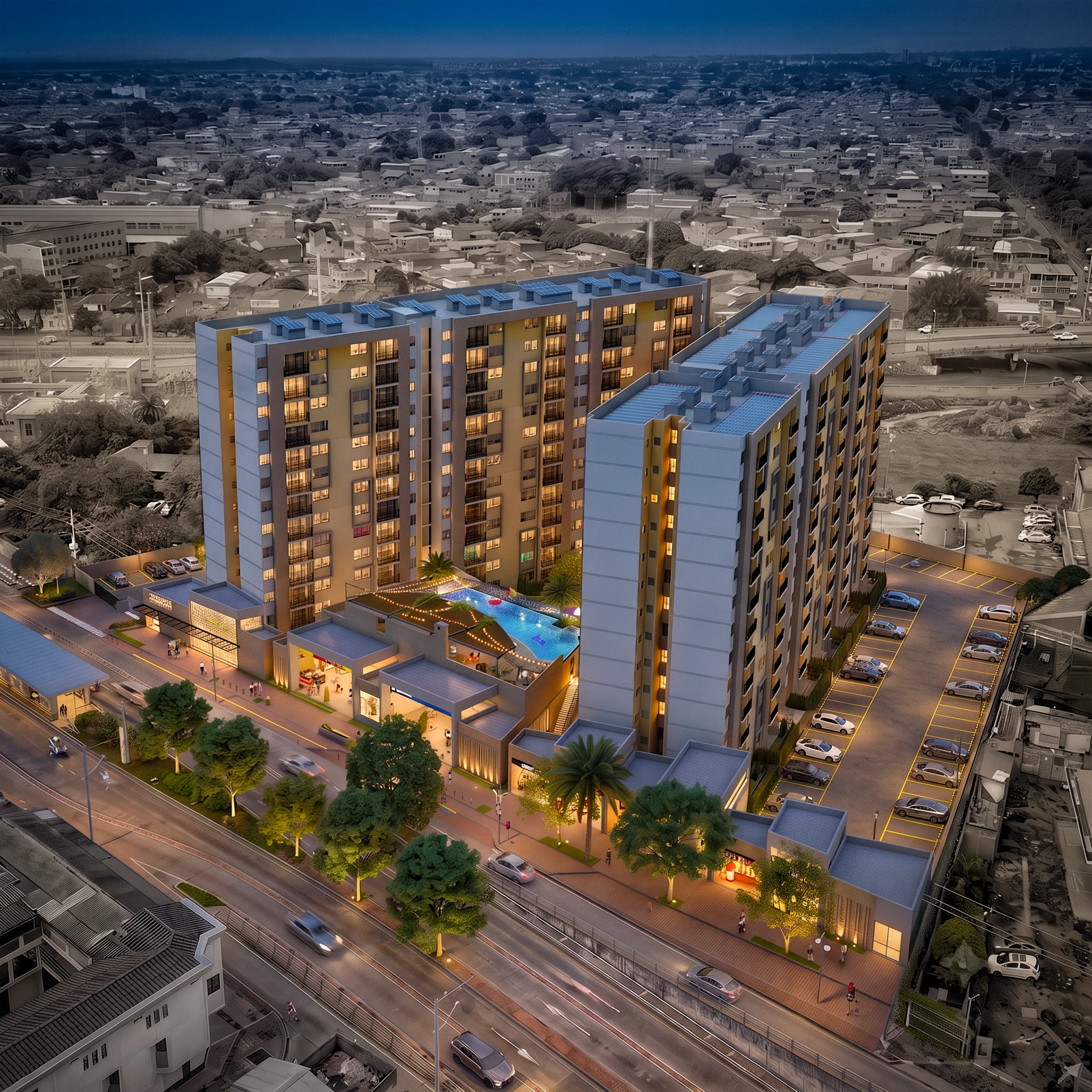 Aerial view of the complex at dusk: the two towers open at an angle around the communal platform — the pool and social area stay protected inside the block — while the plinth of shops lights the pavement and meets the avenue.