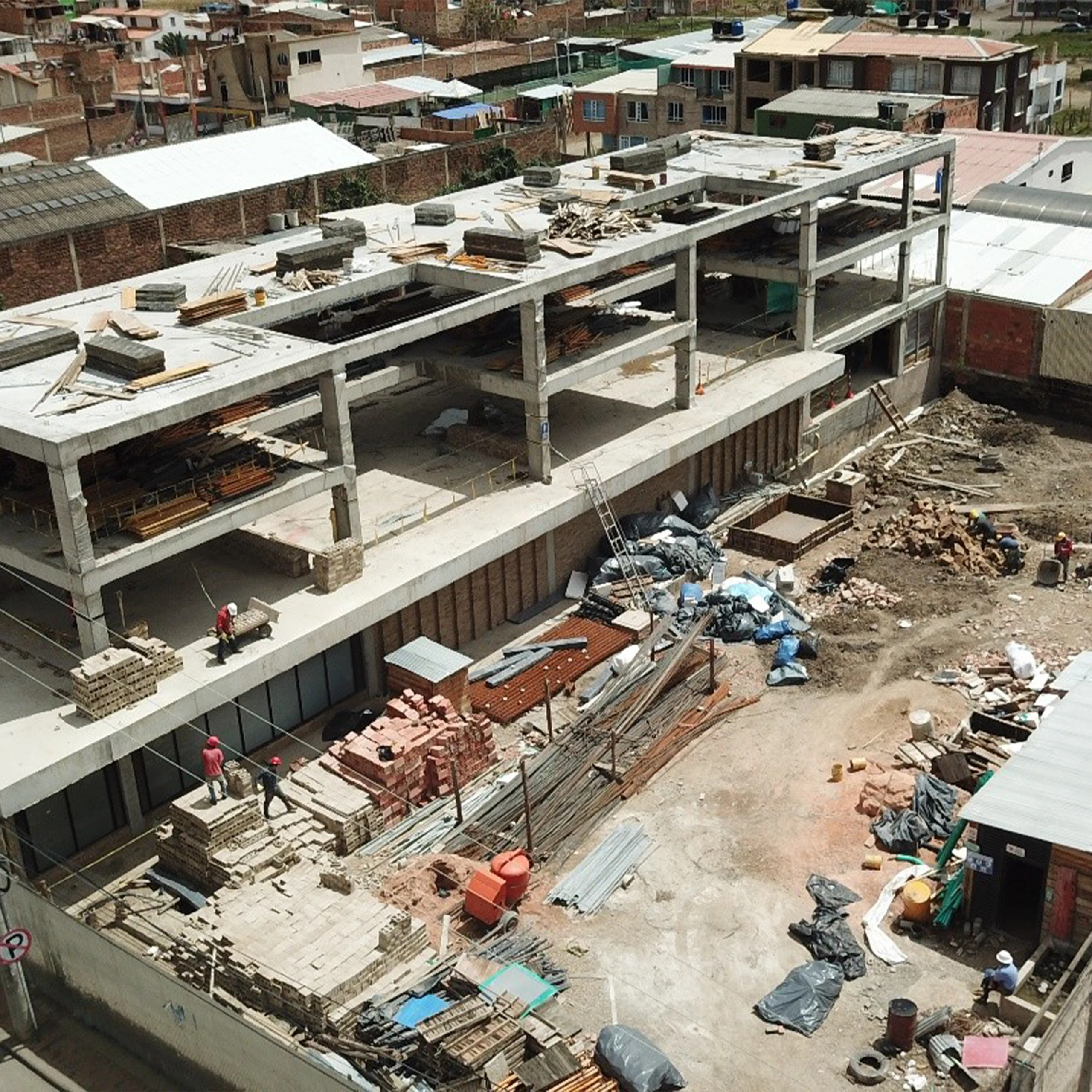 Construction: the concrete frame and clay masonry mid-assembly, with the structural rhythm that later orders the façade.
