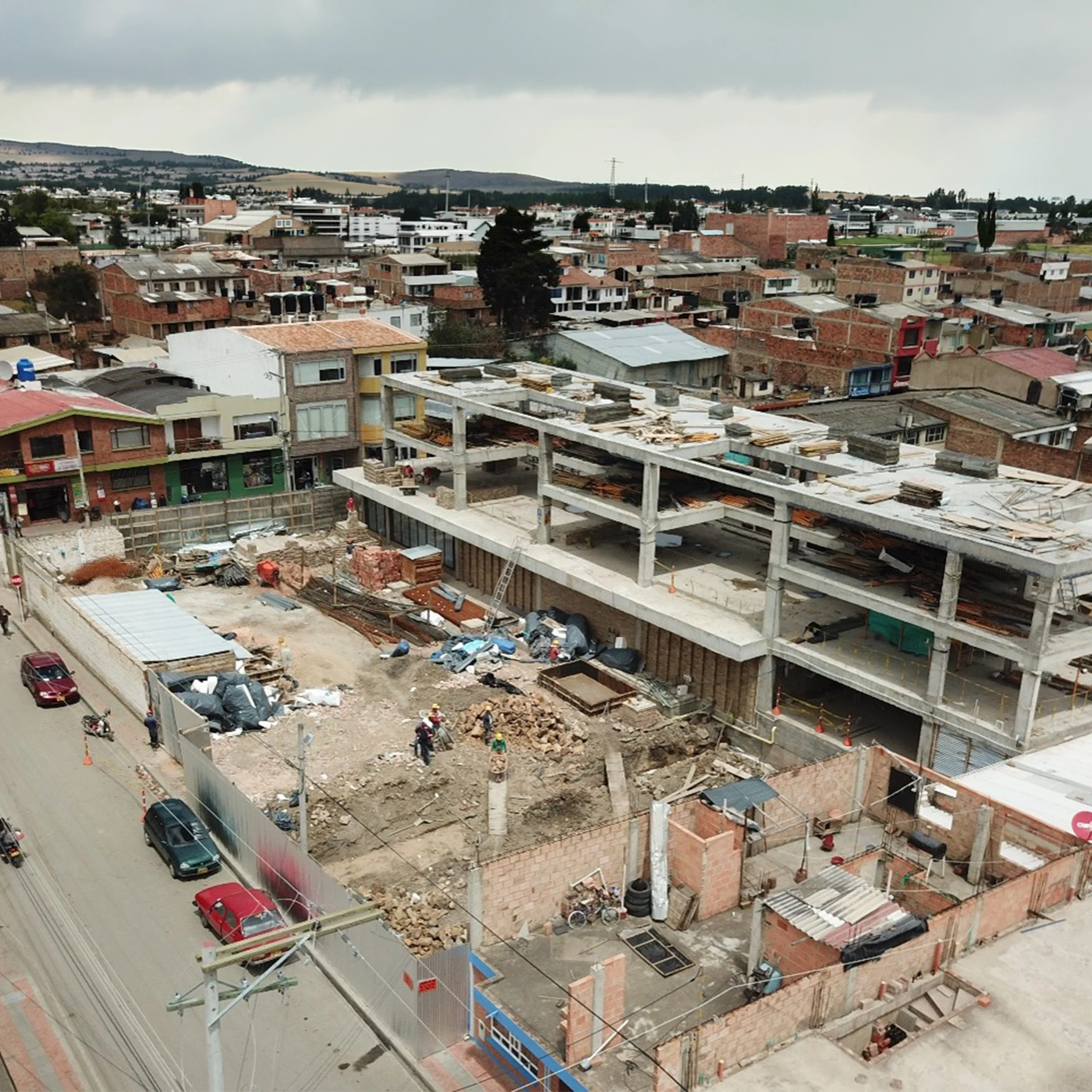 Construction in context: the building rising within Samacá's low-rise fabric, with the hills of the valley behind.