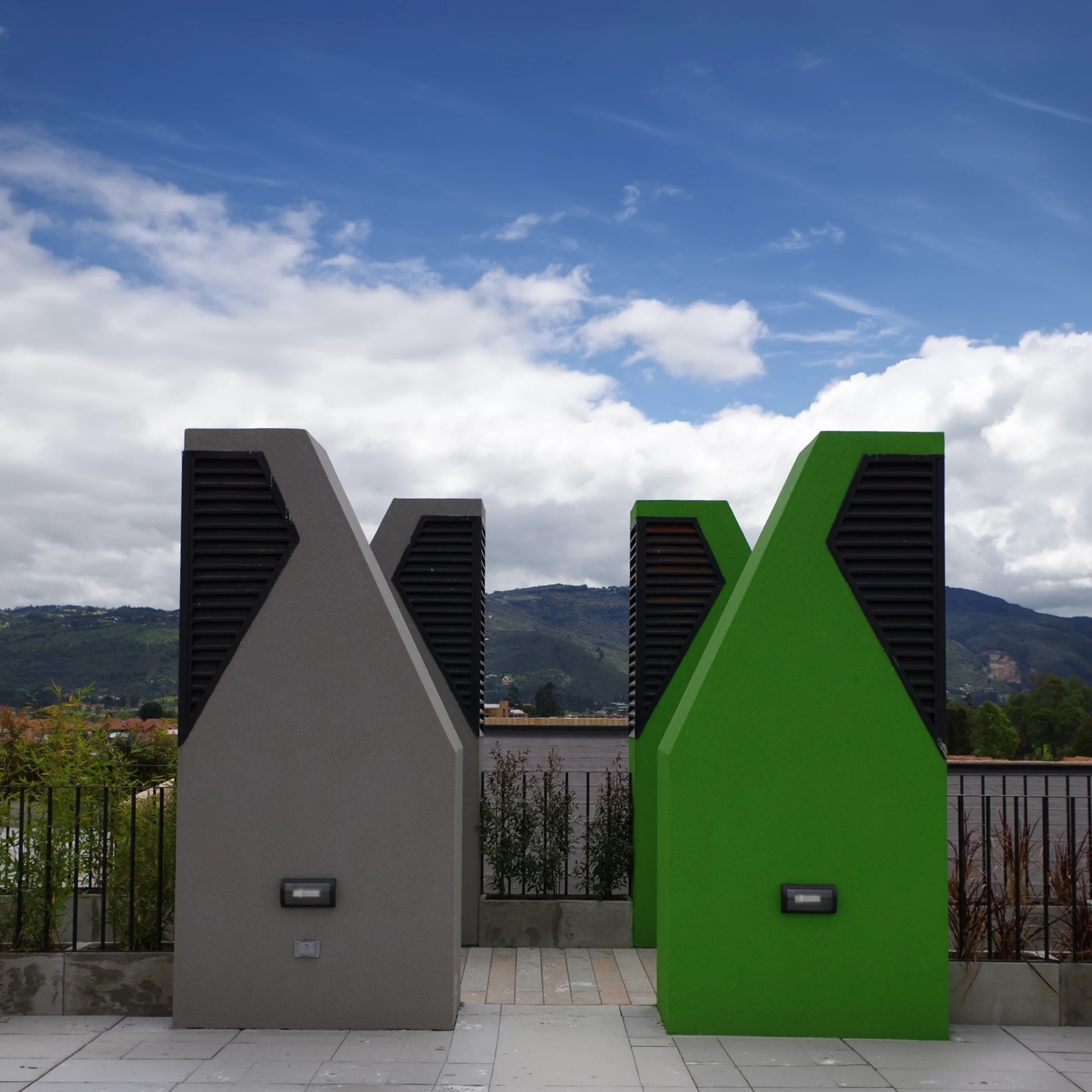 The extractors up close: the angled mouth of each tower ends the journey of the air that begins at the apartment windows, and turns a technical element into the figure you see from the park.