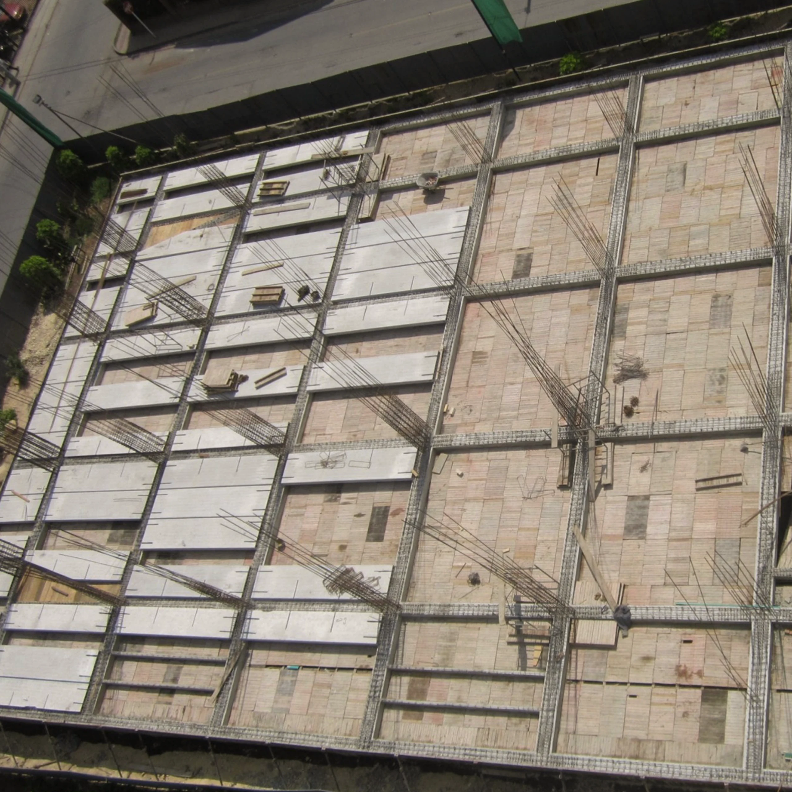 The site during assembly, seen from above: the hollow core slabs arrive ready from the factory and rest on the frame; the building grows by assembly rather than by pouring.