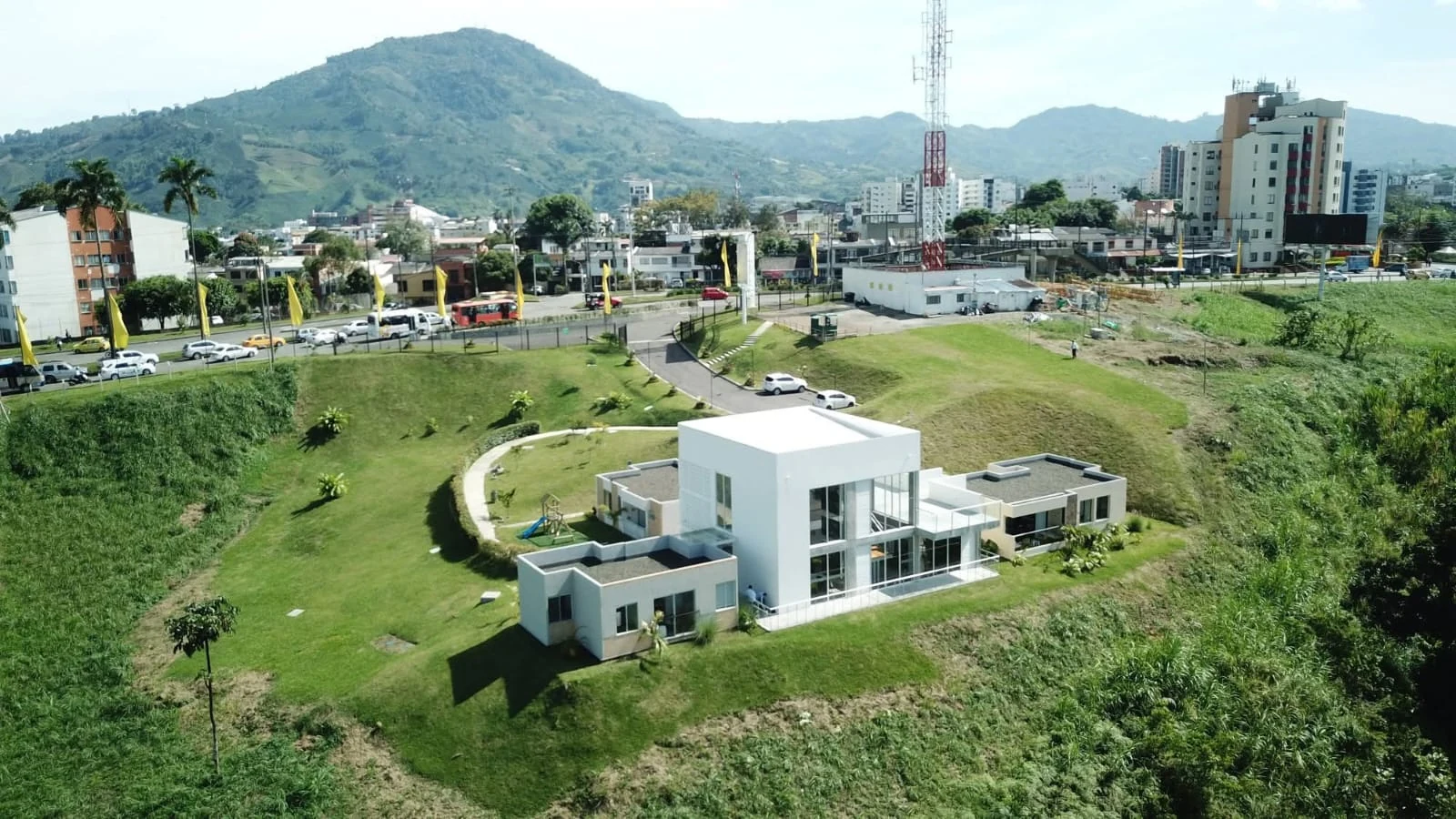 Aerial view from the avenue: the pavilion occupies the high point of the site, with Pereira and the hills behind.