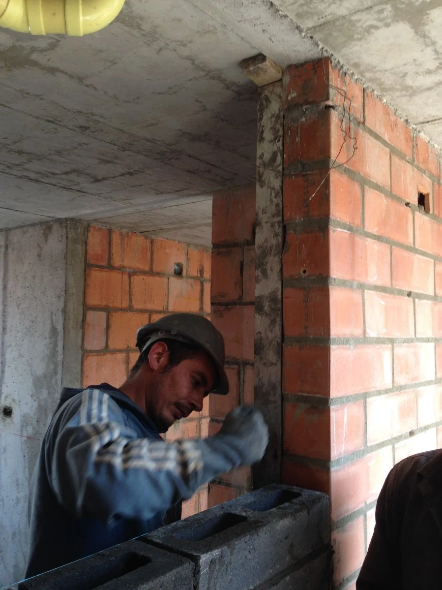 The junction between the brick column and the concrete slab, resolved and finished by hand on site.