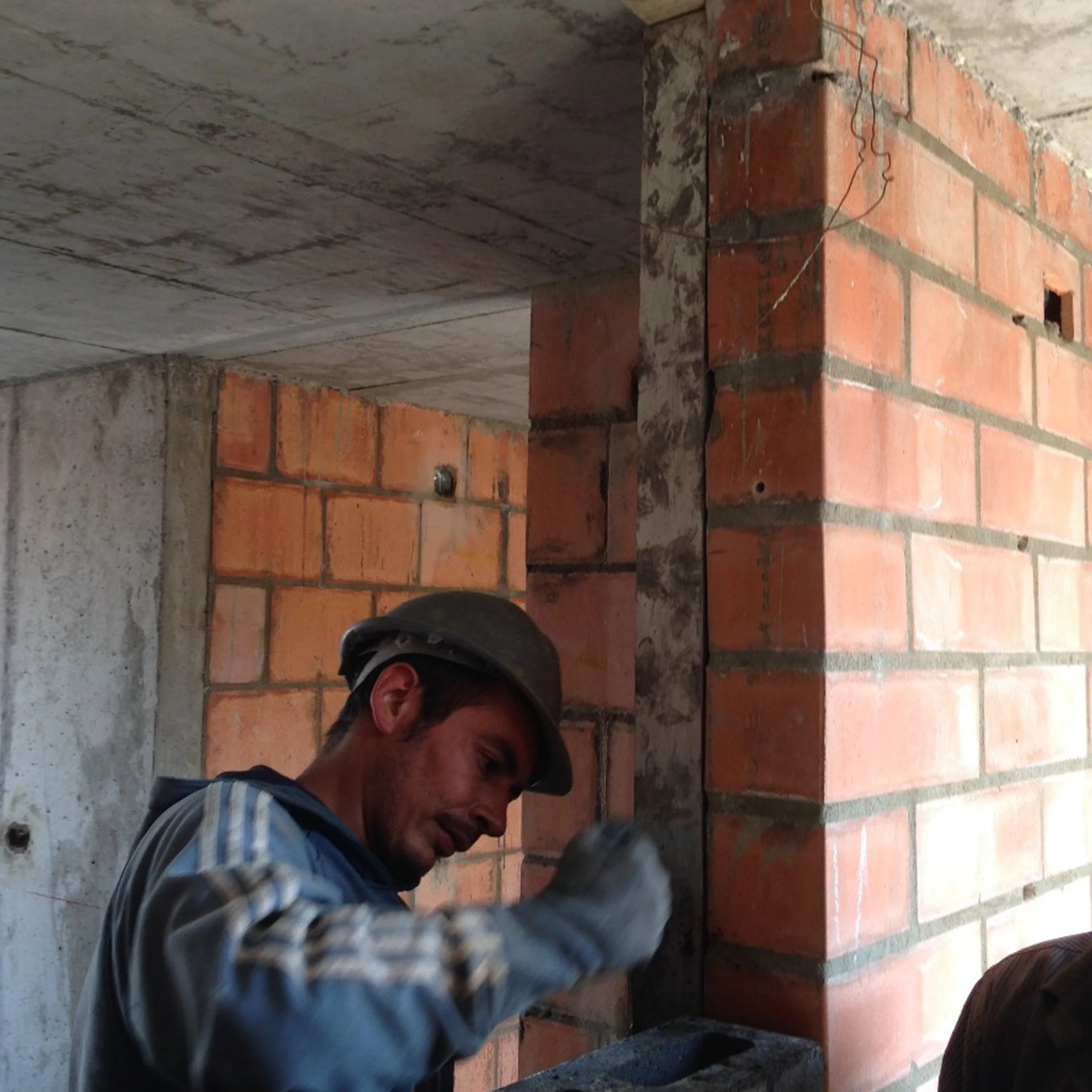 Detail of the same structure-to-brick joint, where the seam against the upper slab is carefully handled.