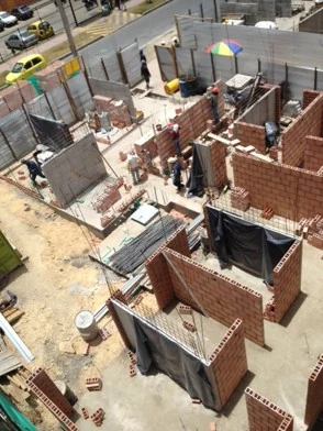 Elevated view of the works: the brick walls already define the homes around the courtyard before roofing.