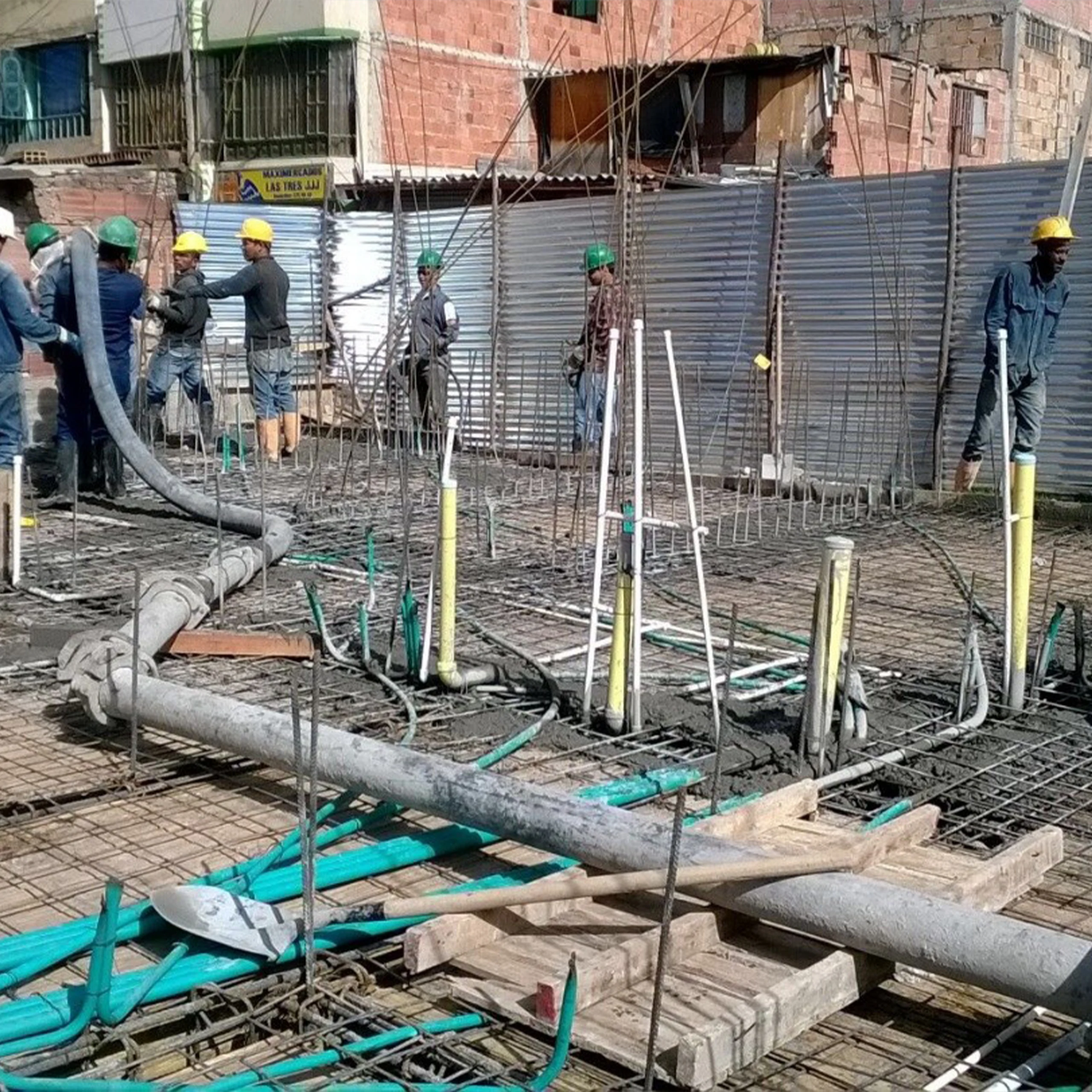 Pouring a slab: the crew places pumped concrete over the reinforcement grid and the networks already laid out.