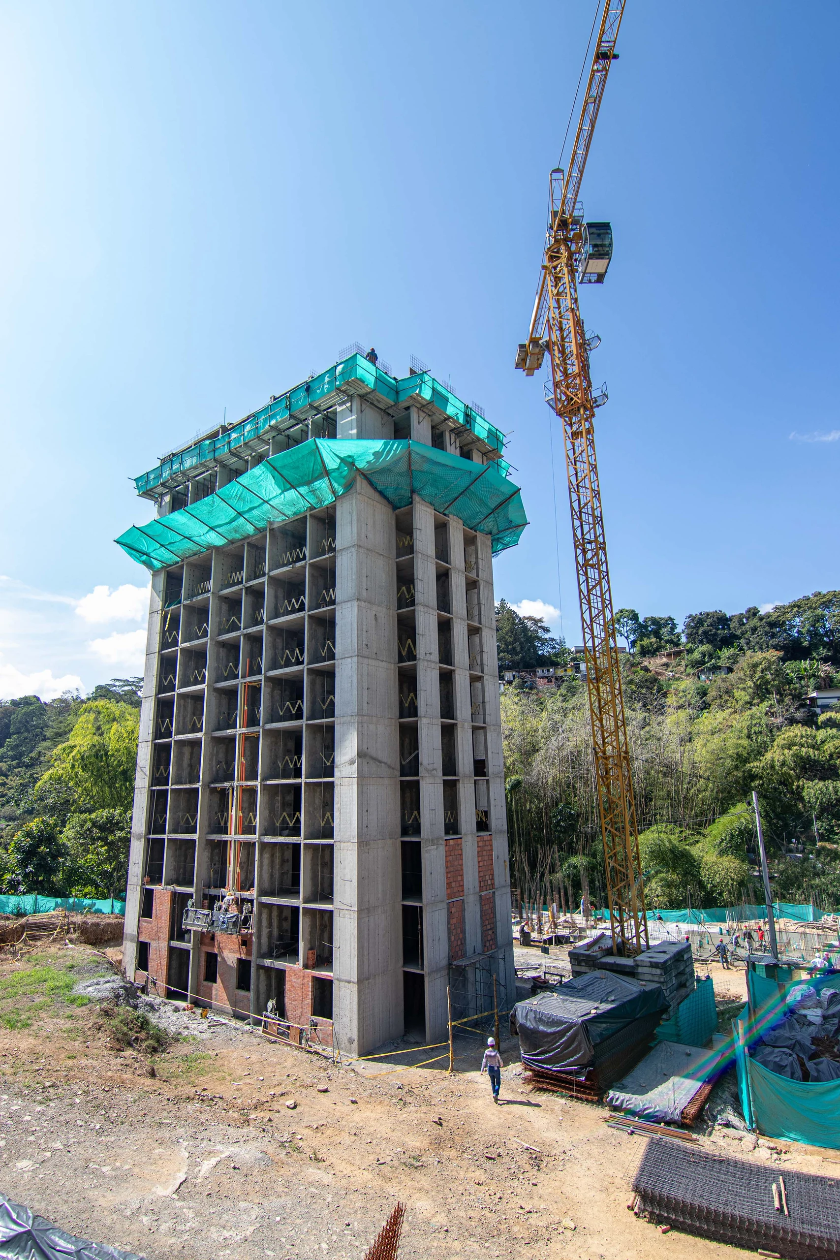 The concrete structure climbs, fitted to the fall of the terrain, with the guadua forest of the Coffee Region surrounding the site.